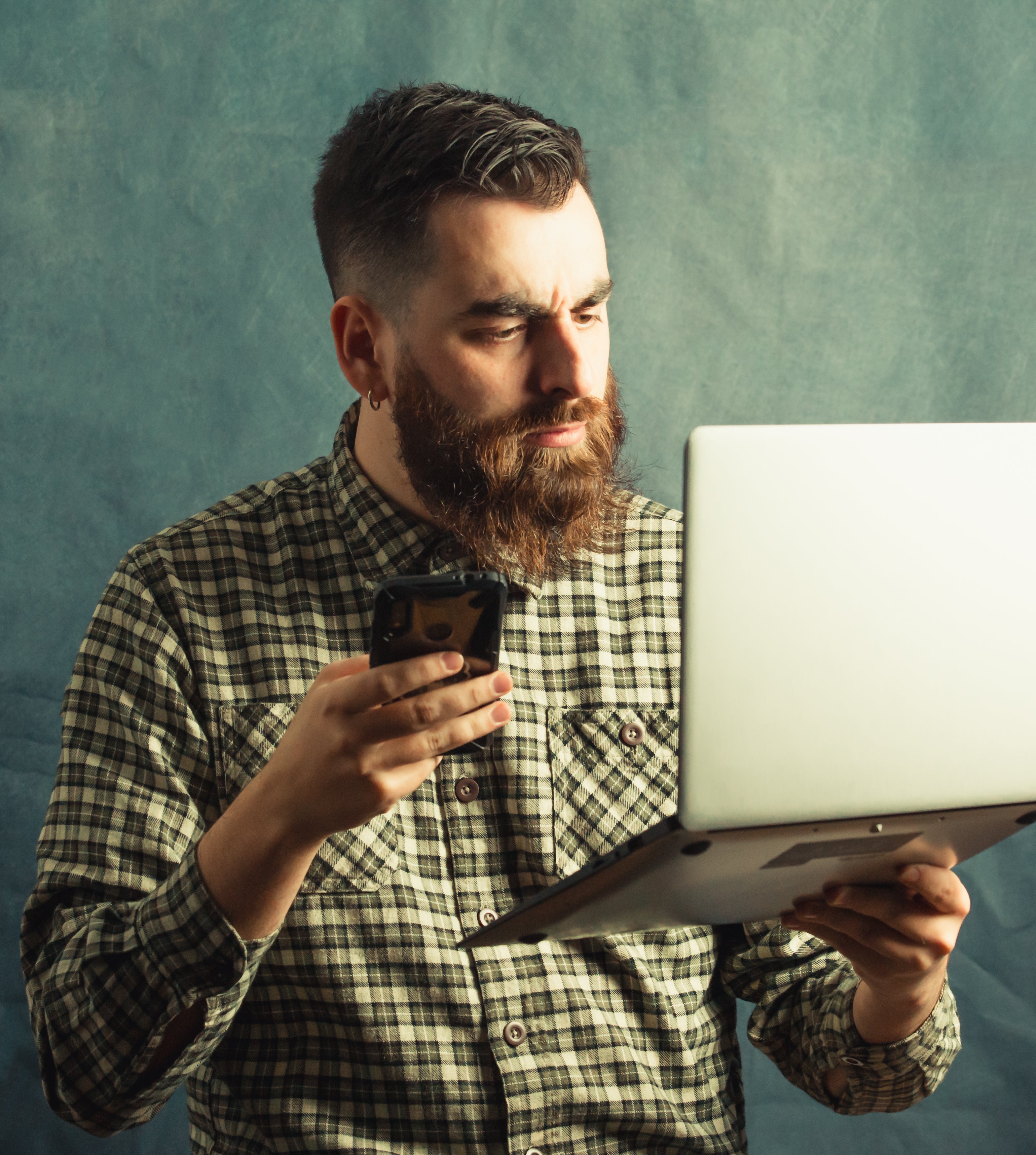 files/man-in-plaid-holds-a-laptop-and-cellphone.jpg